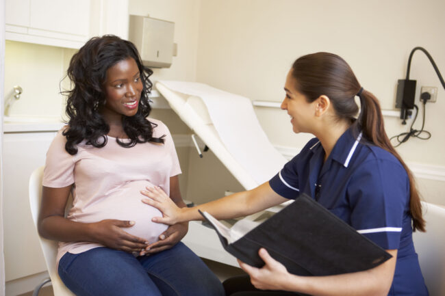 24507941 – pregnant woman being given ante natal check by nurse