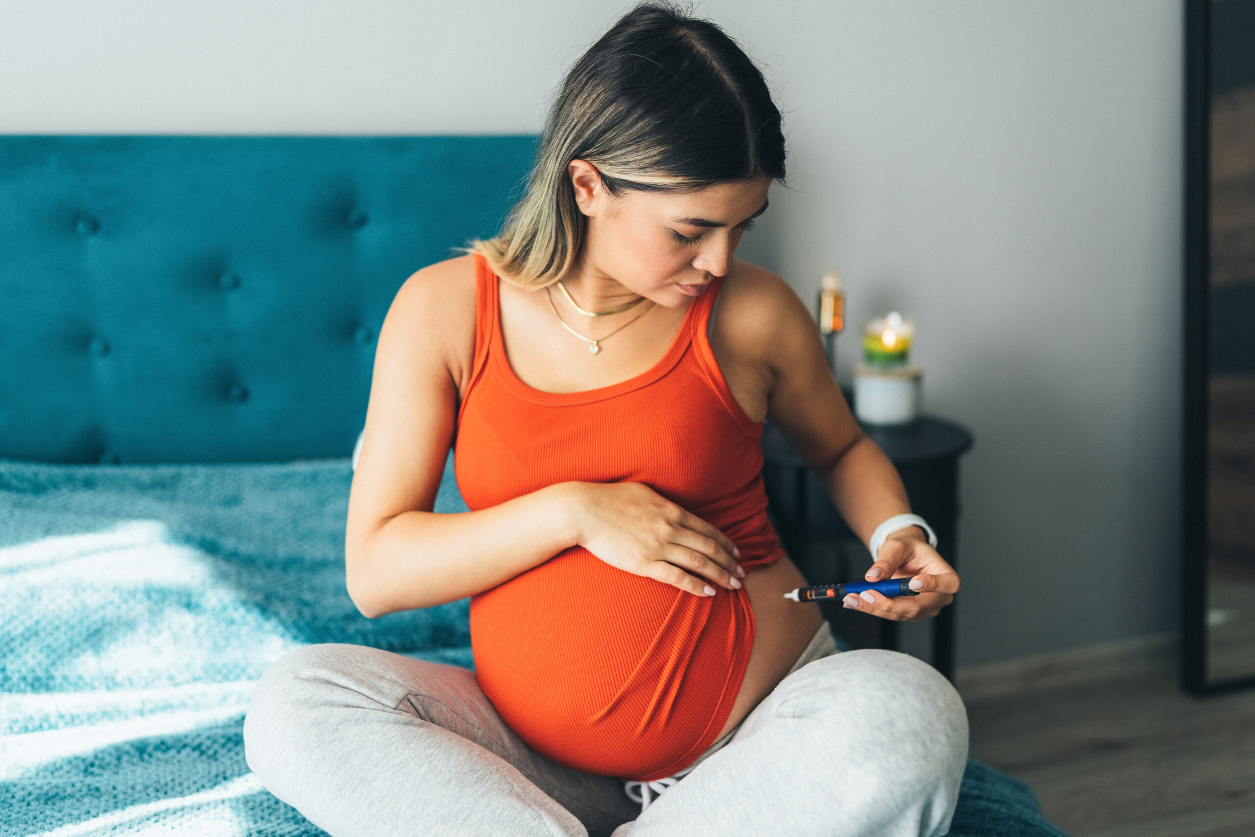 Pregnant young woman injecting insulin with insulin pen